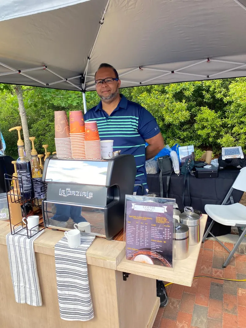 Barista at the espresso stand under a tent at an outdoor market