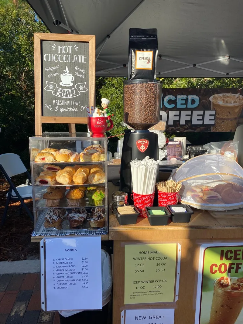Hot chocolate bar sign, pastries, and iced coffee at the stand